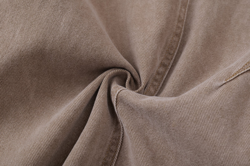 Close-up of tan denim fabric with seam detail and texture