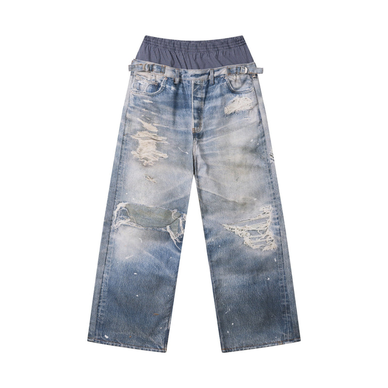 Front view of light wash wide-leg jeans with distressed patches and layered plaid waistband