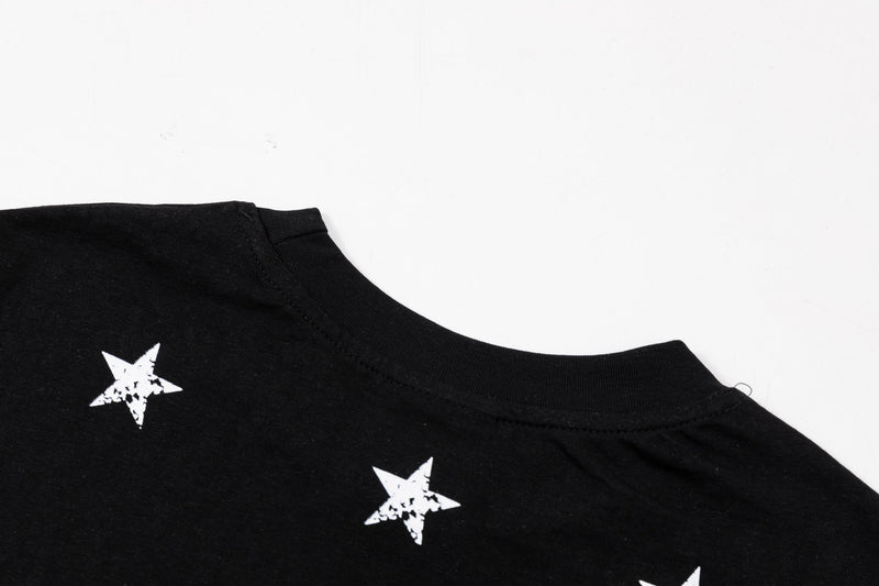 Black oversized graphic tee with distressed white star prints and a ribbed crew neckline on a white background