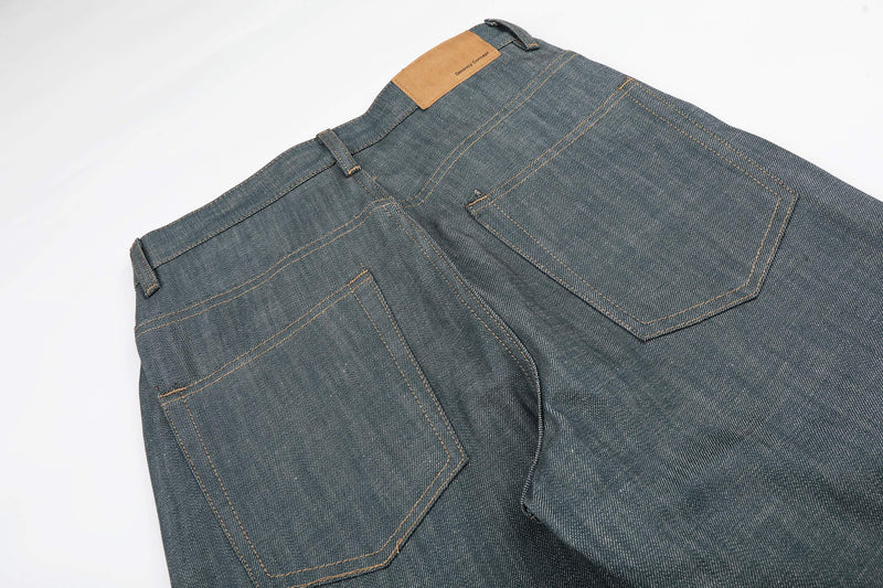 Rear angled view of washed grey wide leg jeans showing back pockets and waistband patch