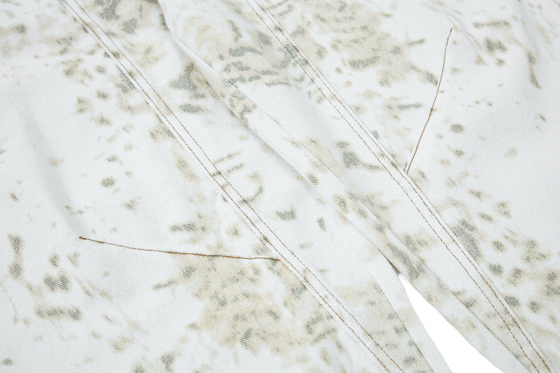 Close-up of side seam and curved panel stitching on white splatter-wash denim
