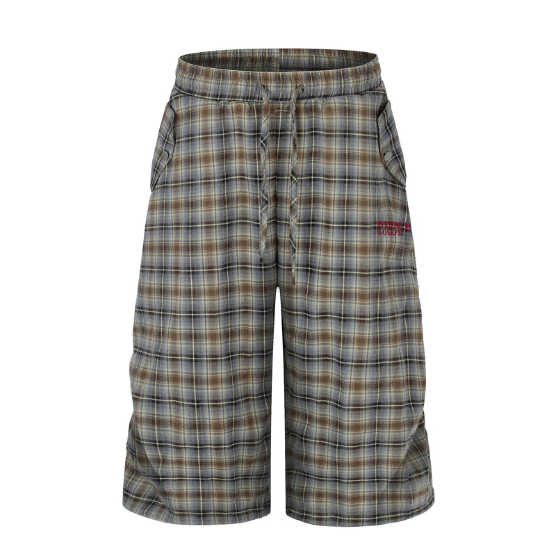 Front view of plaid lounge shorts in blue, brown and cream with oversized wide legs