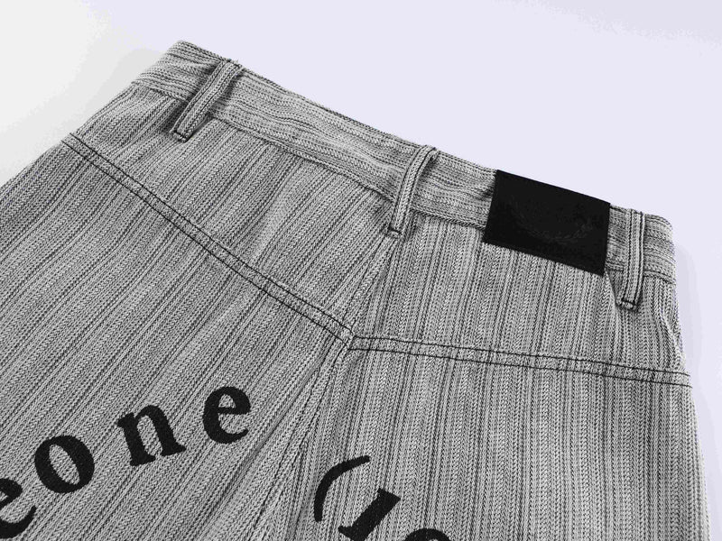 Upper back waistband of gray pants with black label patch and belt loops