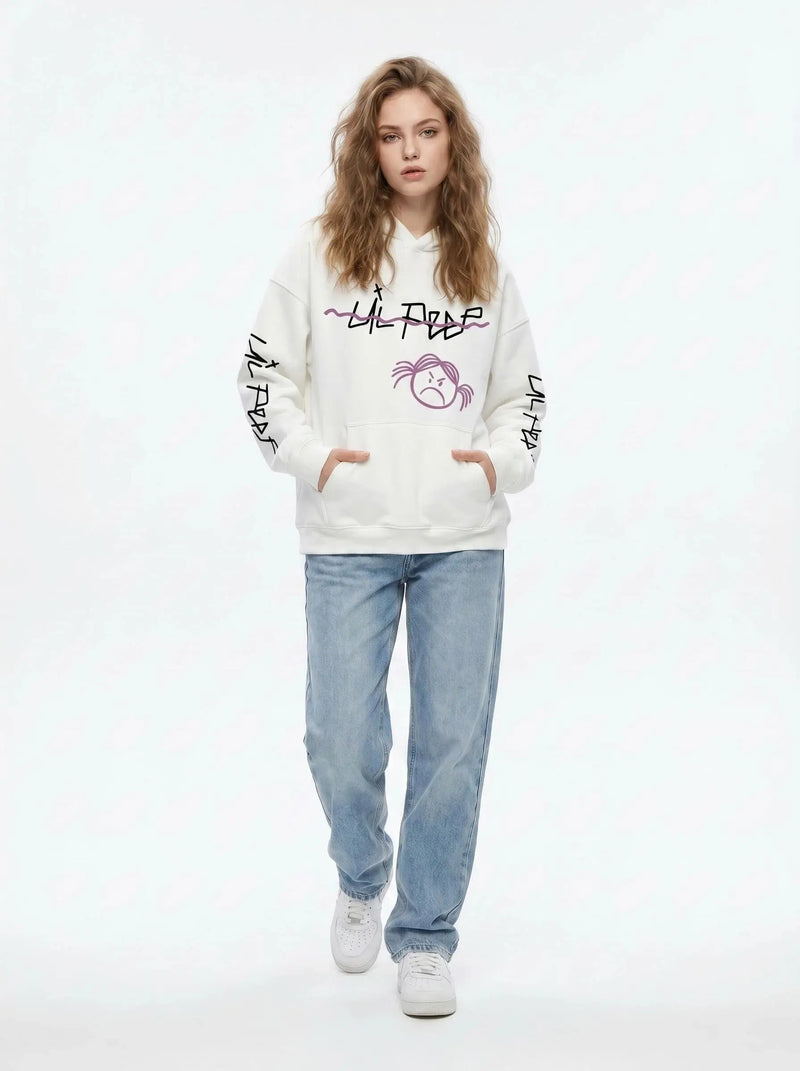 A person with wavy light brown hair wears the Lil Peep Hoodie — Sad Face Graffiti Graphic Sweatshirt, paired with light blue jeans and white sneakers, standing with hands in the hoodie’s pockets against a white background.