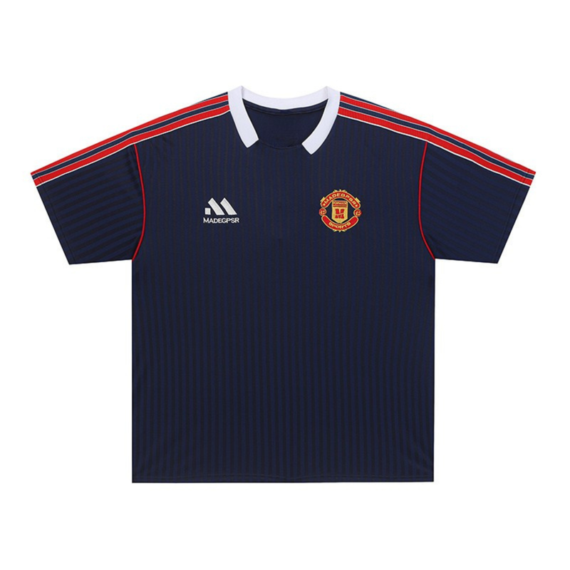 Navy soccer jersey with white V-neck collar, red shoulder stripes, and crest logo on the chest