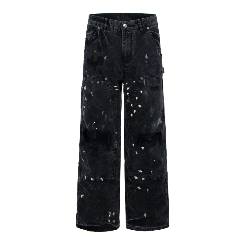 Front view of black distressed denim pants with paint splatter and ripped knees