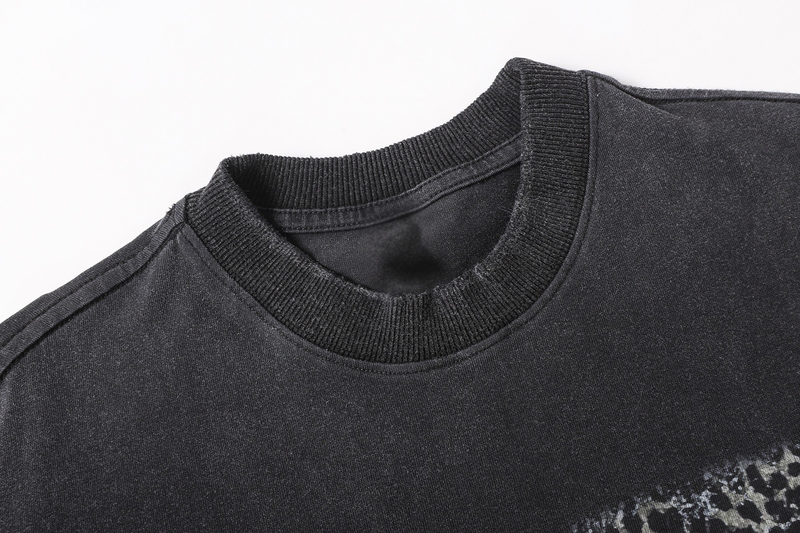 Close-up of black ribbed crew neckline on the layered camo sleeve graphic tee