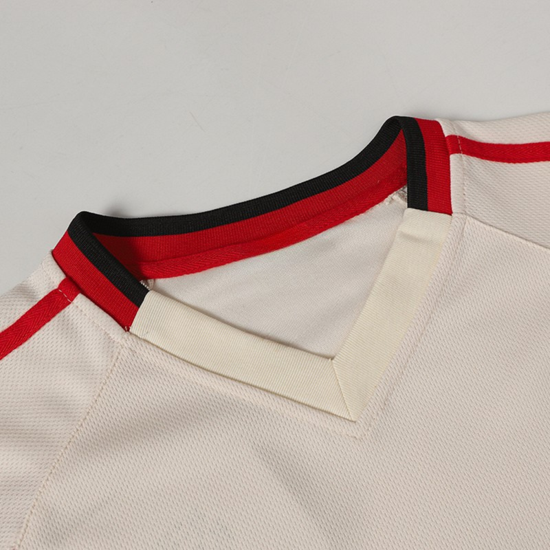 White performance soccer jersey with red and black trim at the collar and shoulders, close-up detail view