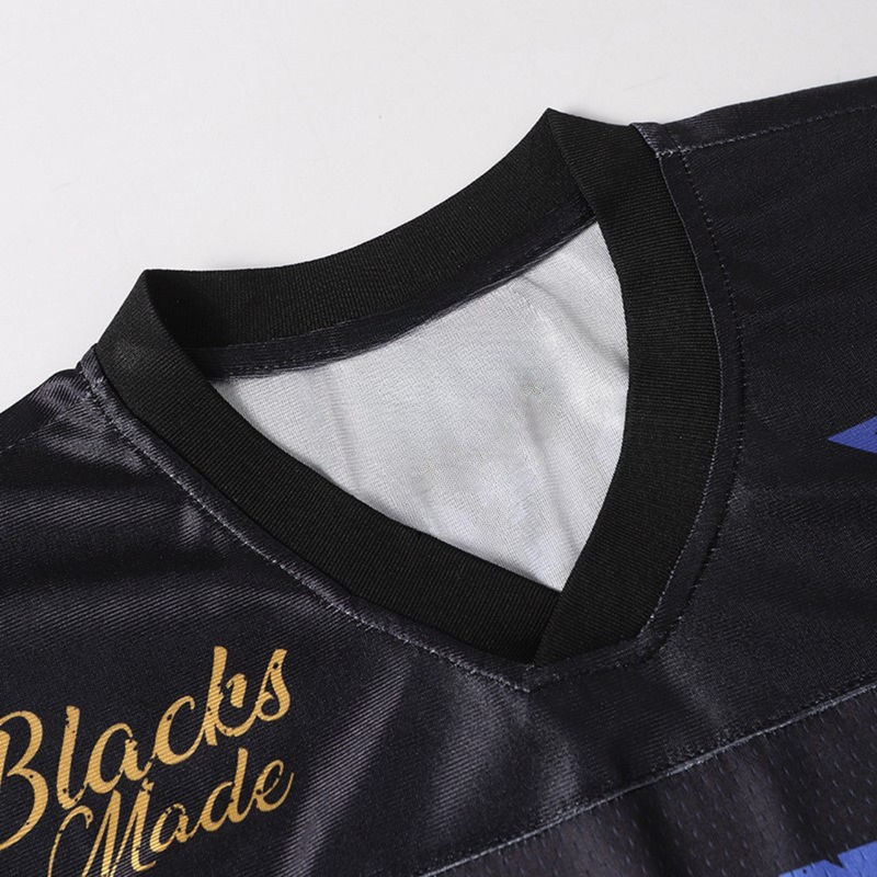 Black mesh football jersey with ribbed V-neck, gold script detail, and blue accents on the shoulder