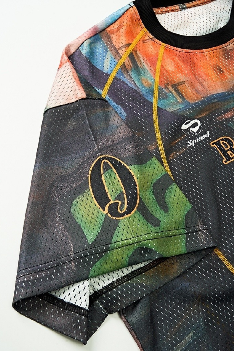 Multicolor mesh racing jersey with abstract graphics, yellow seams, and black ribbed collar on a white background