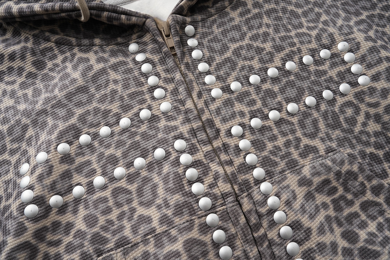 Close-up of leopard print studded cross pattern across the front of the hoodie