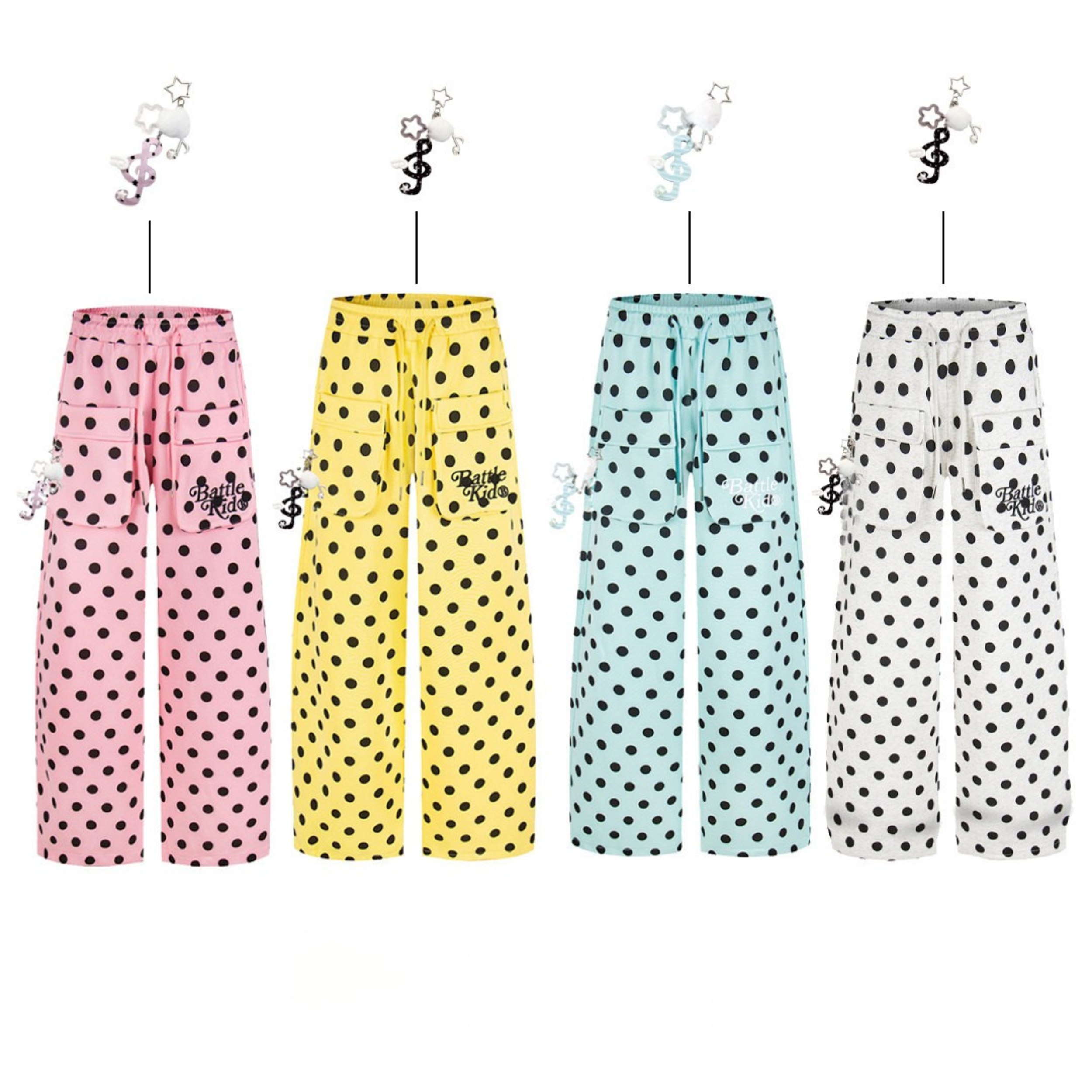 Pink wide-leg polka dot cargo pants with black dots, cargo pockets, drawstring waist, and musical note charm accessory