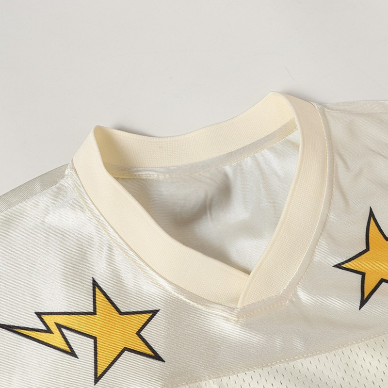 Cream varsity football jersey with cream ribbed collar and yellow star graphics on white mesh fabric