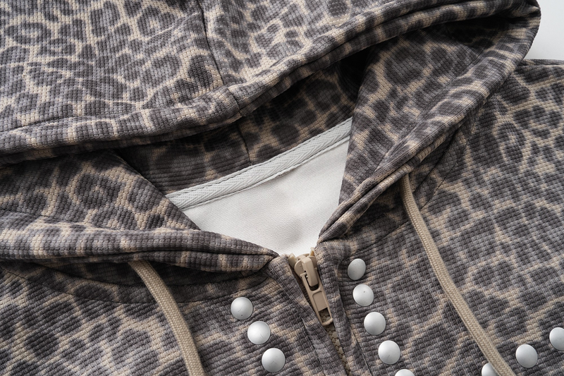 Close-up of leopard print hood lining, zipper, studs, and drawstrings