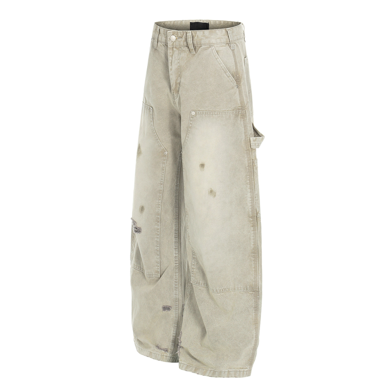 Angled front view of beige wide leg carpenter jeans with side utility pocket and distressed marks
