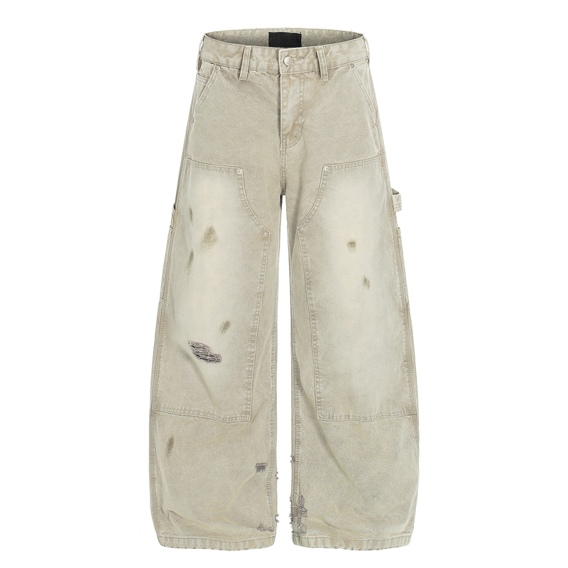 Front view of washed beige distressed wide leg carpenter jeans with knee patches and rips