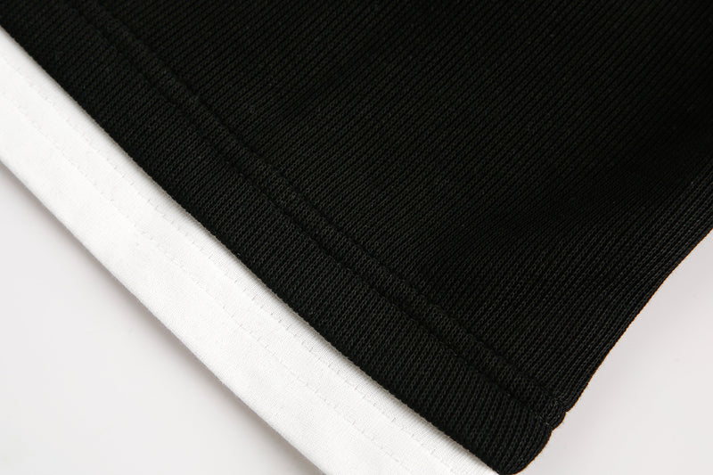 Close-up of black sleeve hem with white trim
