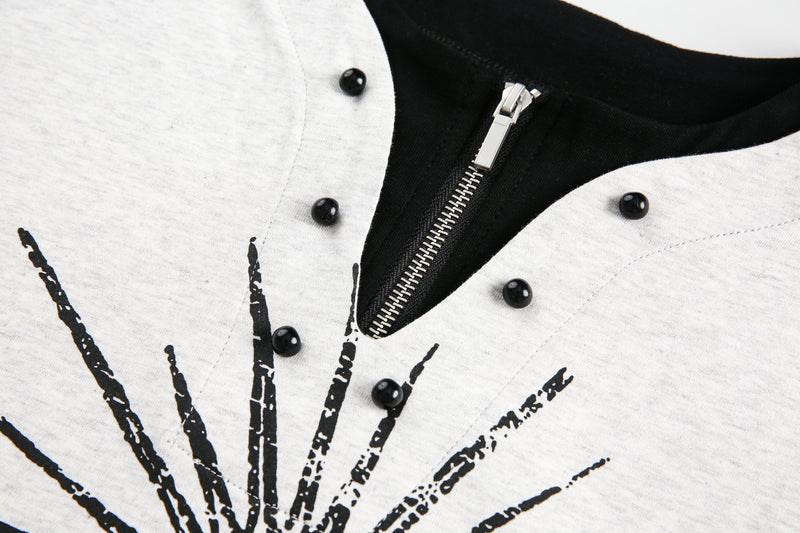 Close-up of zipper neckline and distressed black graphic on light gray tee