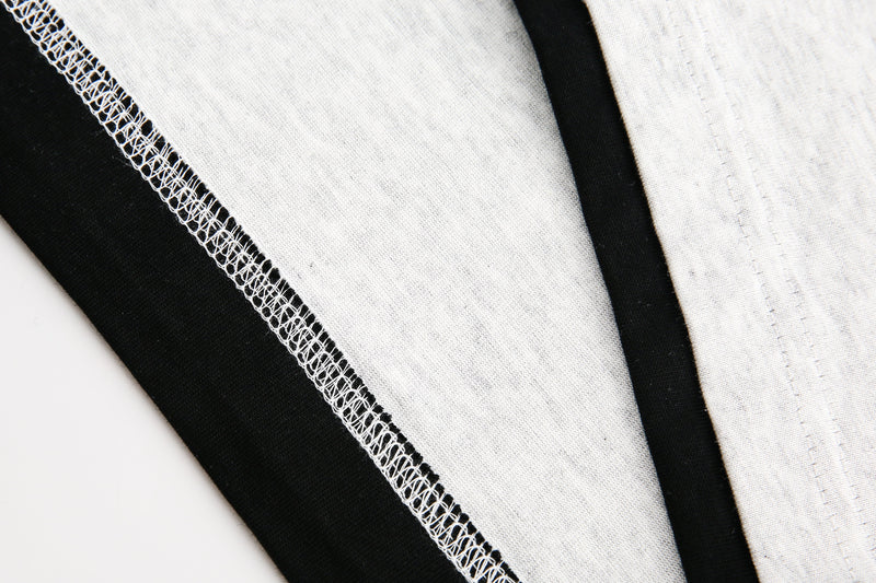 Seam detail on light gray sleeve with black inner layer and overlock stitching