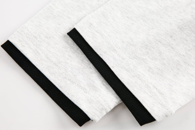 Cuffed sleeve detail on light gray tee with black trim at the edge