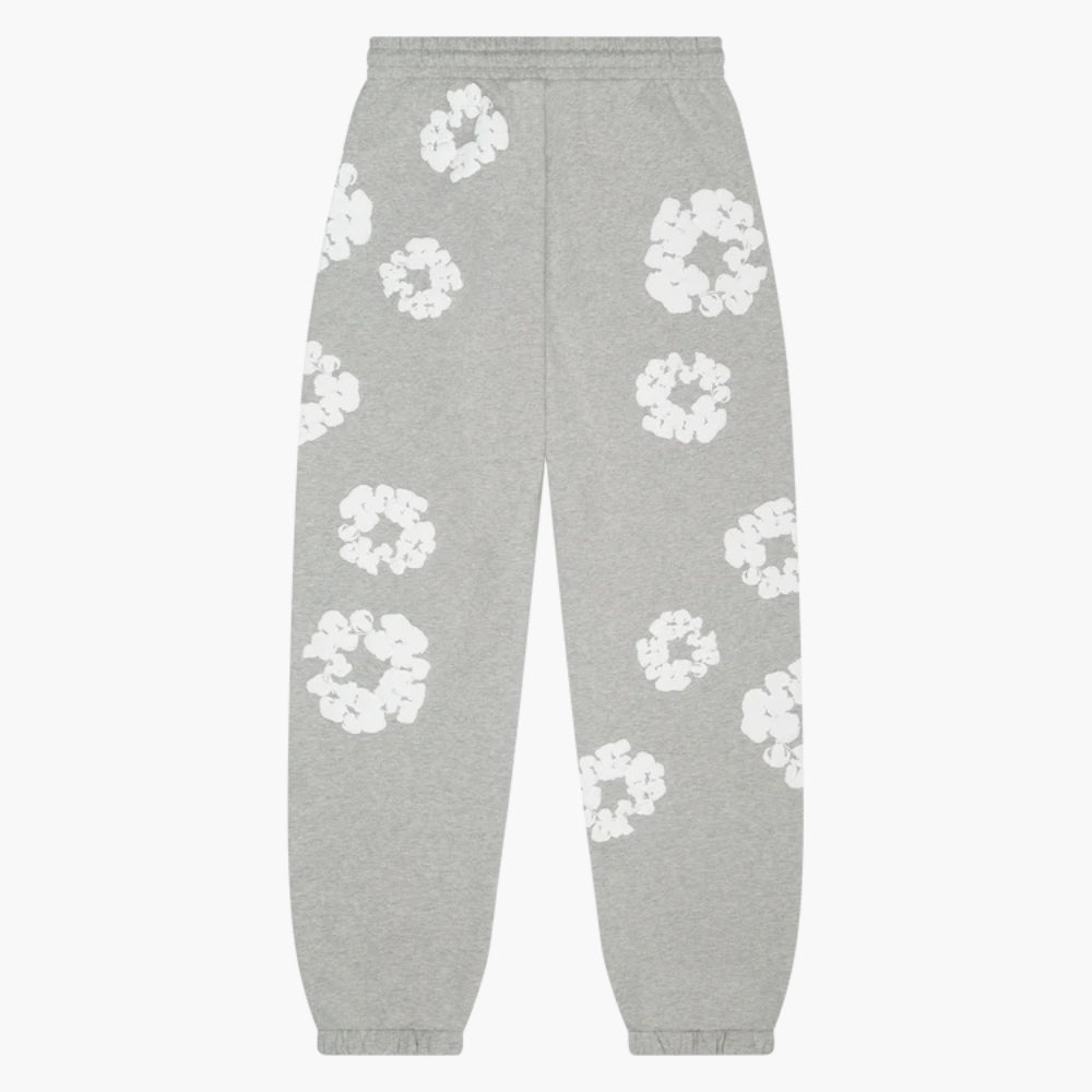 Grey “Cotton Wreath” Denim Tears Sweatpants feature an elastic waistband and cuffs, with a white floral print on grey fabric, inspired by classic streetwear style.