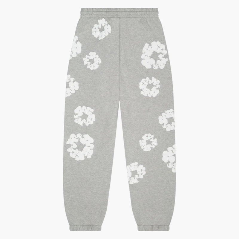 Grey “Cotton Wreath” Denim Tears Sweatpants feature an elastic waistband and cuffs, with a white floral print on grey fabric, inspired by classic streetwear style.