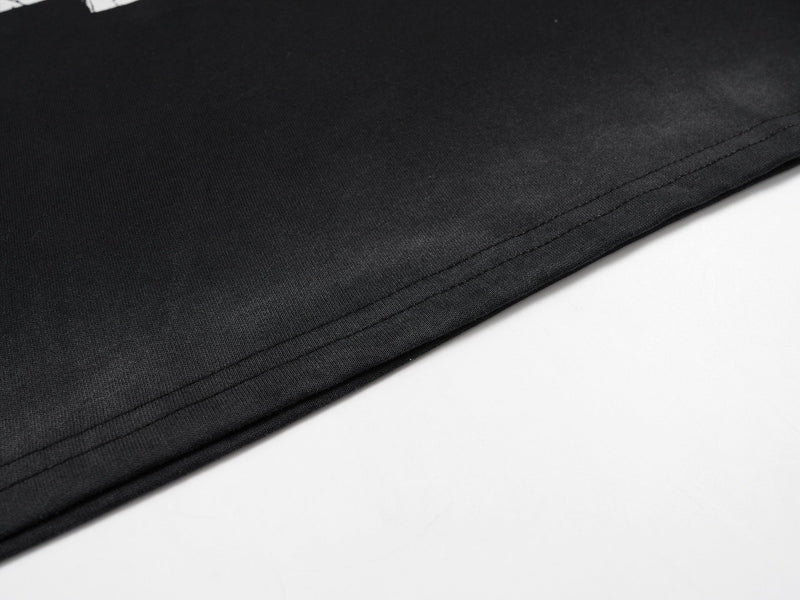Close-up of black jersey bottom hem stitching on smooth faded fabric