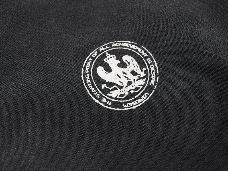 Close-up of circular white crest patch on black jersey chest