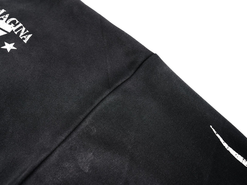 Close-up of black jersey shoulder and sleeve seam with partial front print