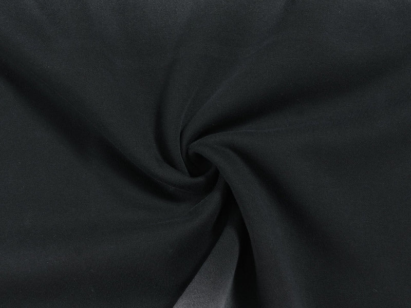 Close-up of black jersey fabric texture gathered into a swirl