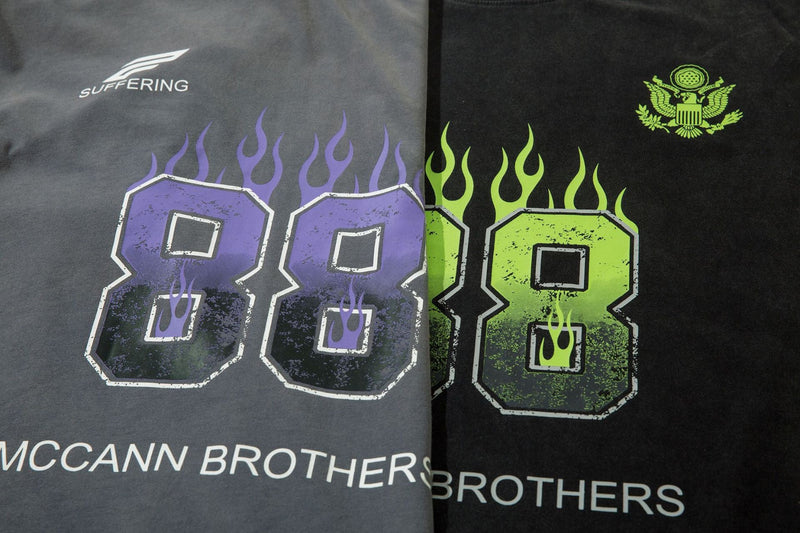 Side-by-side view of charcoal and black long sleeve tees showing purple and neon green flame graphics