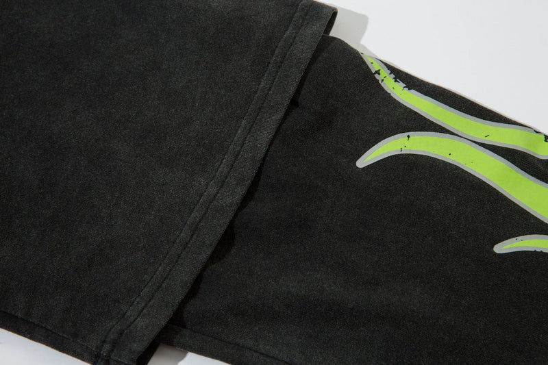 Close-up of black sleeve and shoulder with neon green flame graphic