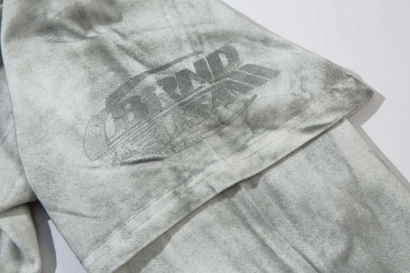 Close-up of gray sleeve with faded brand logo print near the cuff