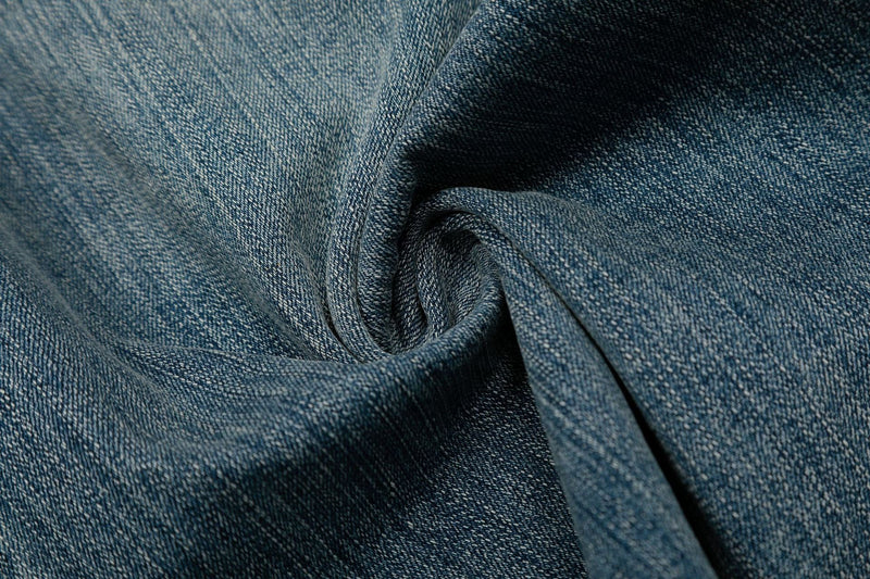 Close-up of washed denim fabric texture on wide-leg shorts