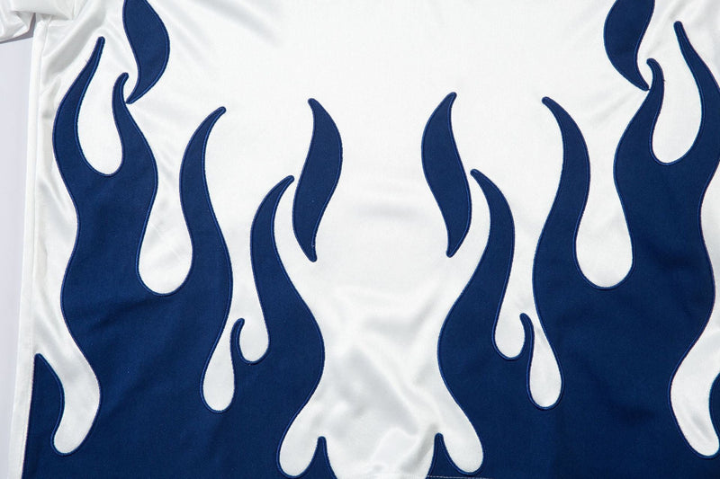 Close-up of white jersey front with blue flame graphics across the chest