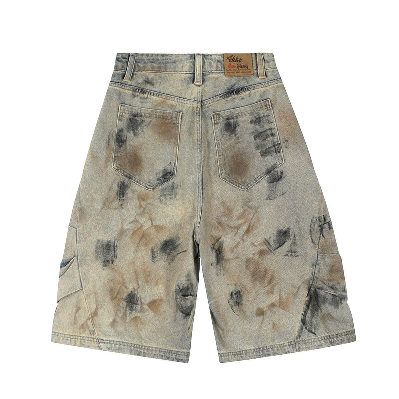 Back view of spray-dyed wide-leg denim shorts with patch pockets and tan label at waistband