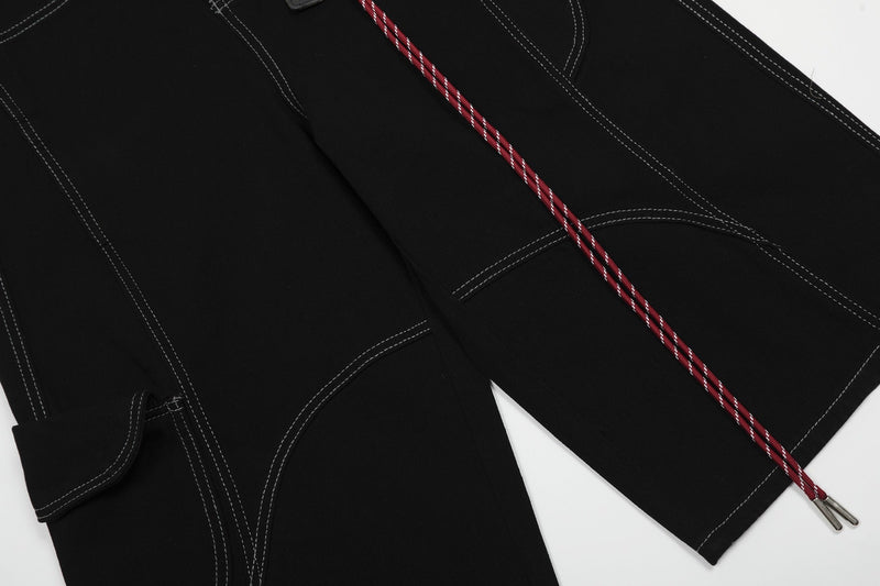 Front and back panels of black cargo shorts with red cord keychain detail