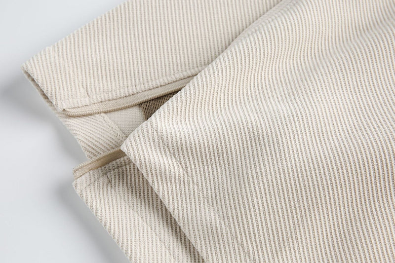 Close-up of beige ribbed layered tee with structured chest panel and zipper detail