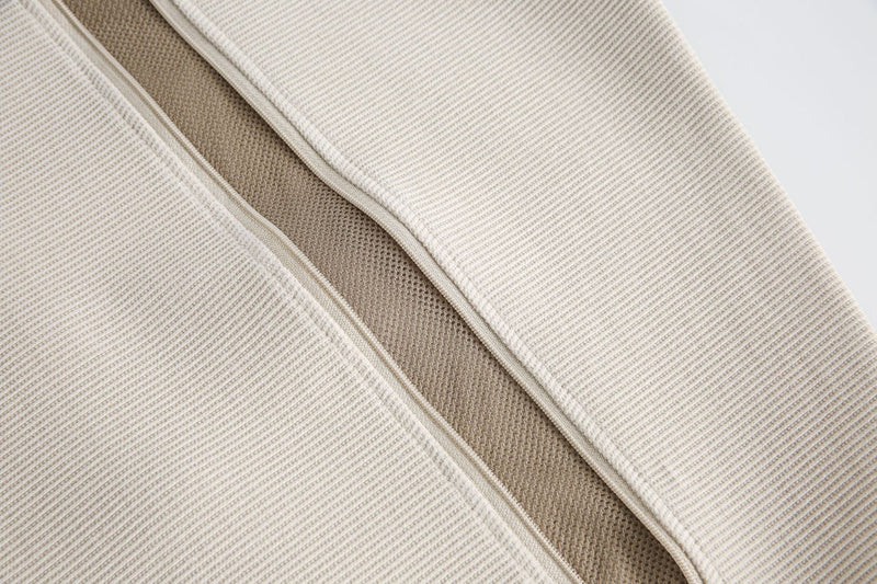 Close-up of beige ribbed tee with layered chest panel and contrasting textured center seam detail