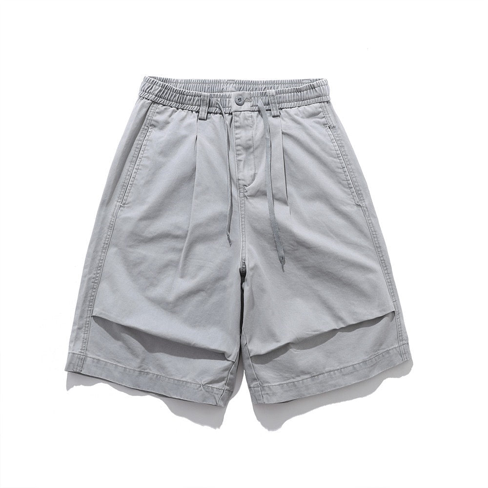 Front view of men's light grey relaxed-fit drawstring shorts with elastic waistband and layered front panel detail