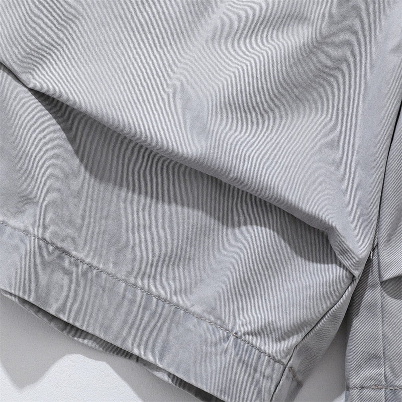 Close-up of light gray shorts hem with stitched cuff detail