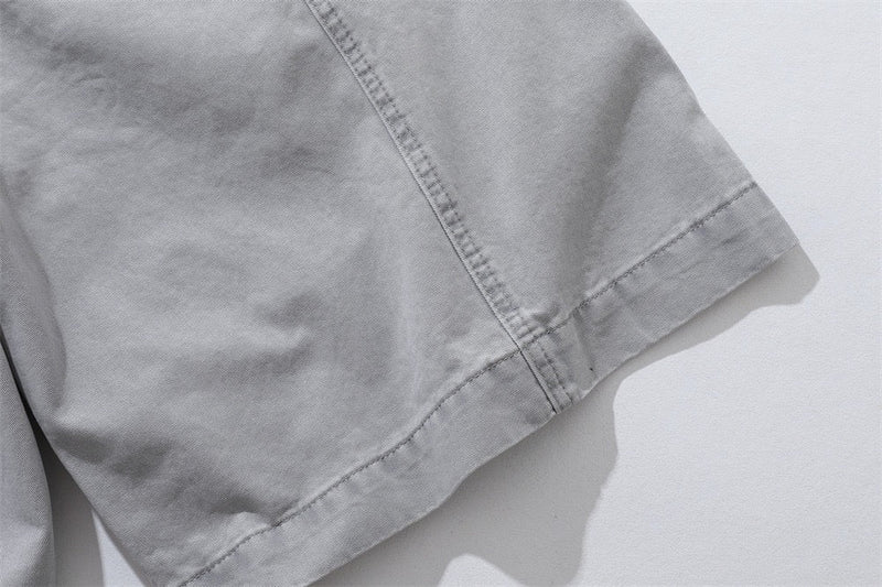 Close-up of light gray shorts side hem and seam stitching