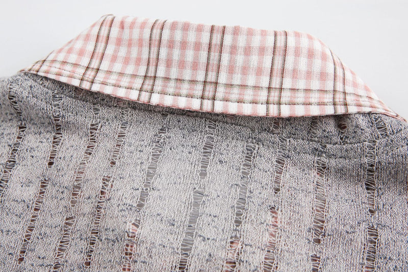 Close-up of a gray mesh graphic tee with a pink plaid collar and distressed vintage streetwear texture
