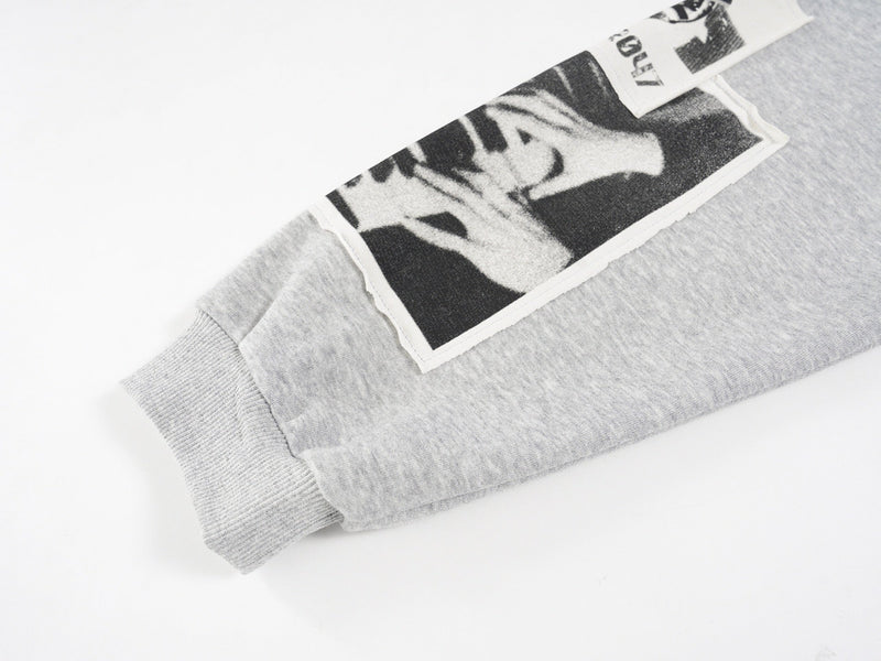 Close-up of the light gray hoodie sleeve print with black-and-white face collage patch