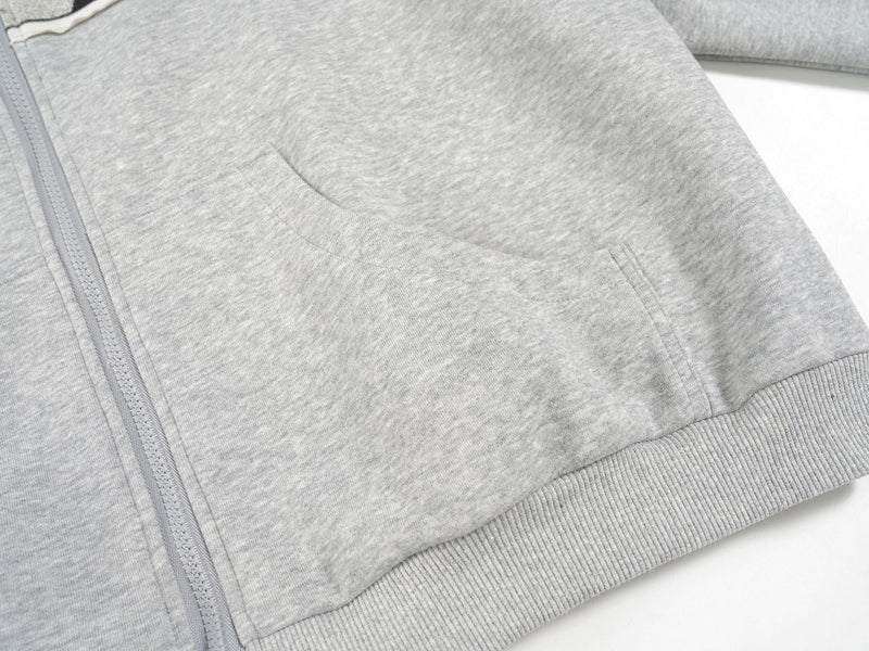 Close-up of the light gray hoodie front pocket and zipper seam