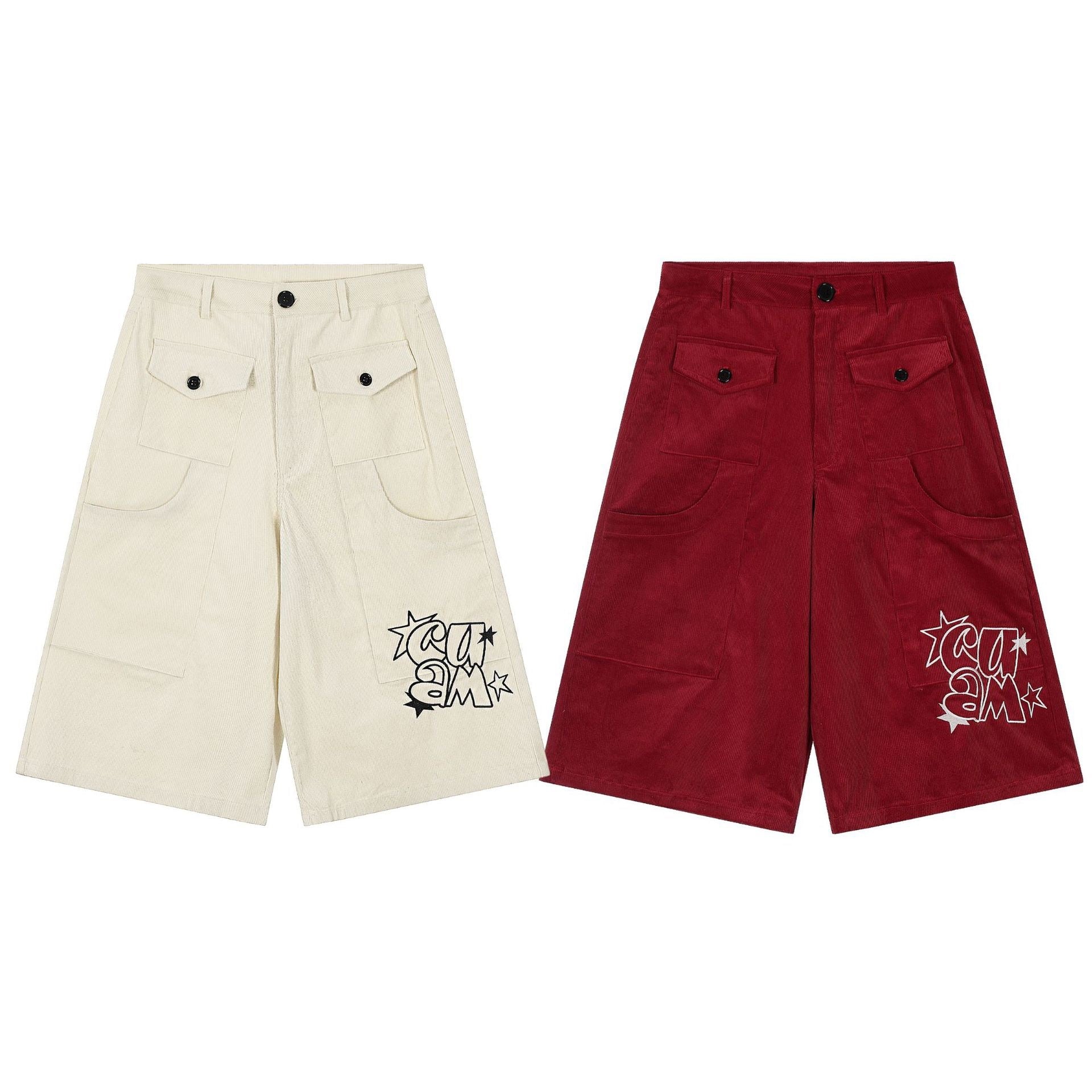 Cream and red corduroy wide-leg cargo shorts with buttoned flap pockets and graffiti graphic embroidery on left leg