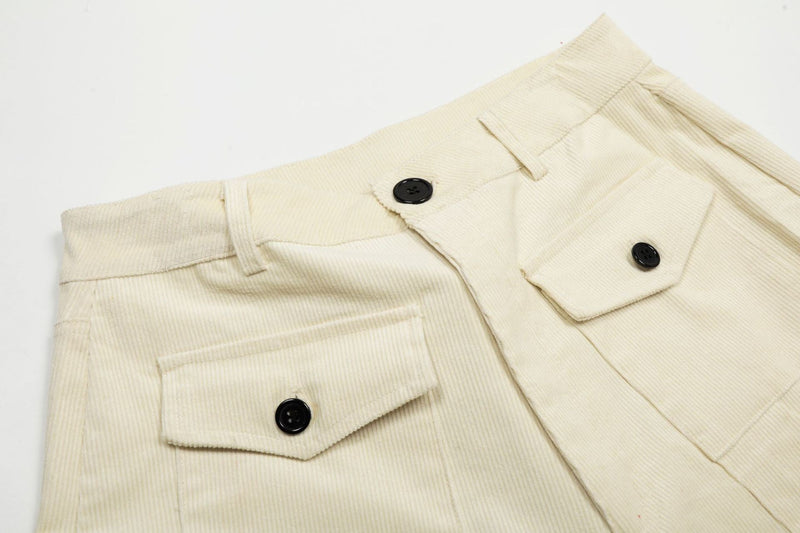Close-up of cream corduroy shorts waistband and front cargo pocket with black button