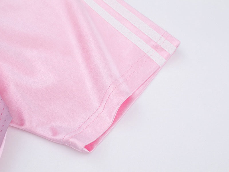 Light pink mesh soccer jersey sleeve with white stripes and stitched hem on a soft gradient tee