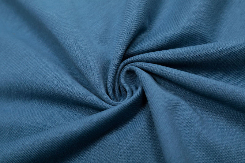 Close-up of blue cotton T-shirt fabric with soft folds and textured knit finish
