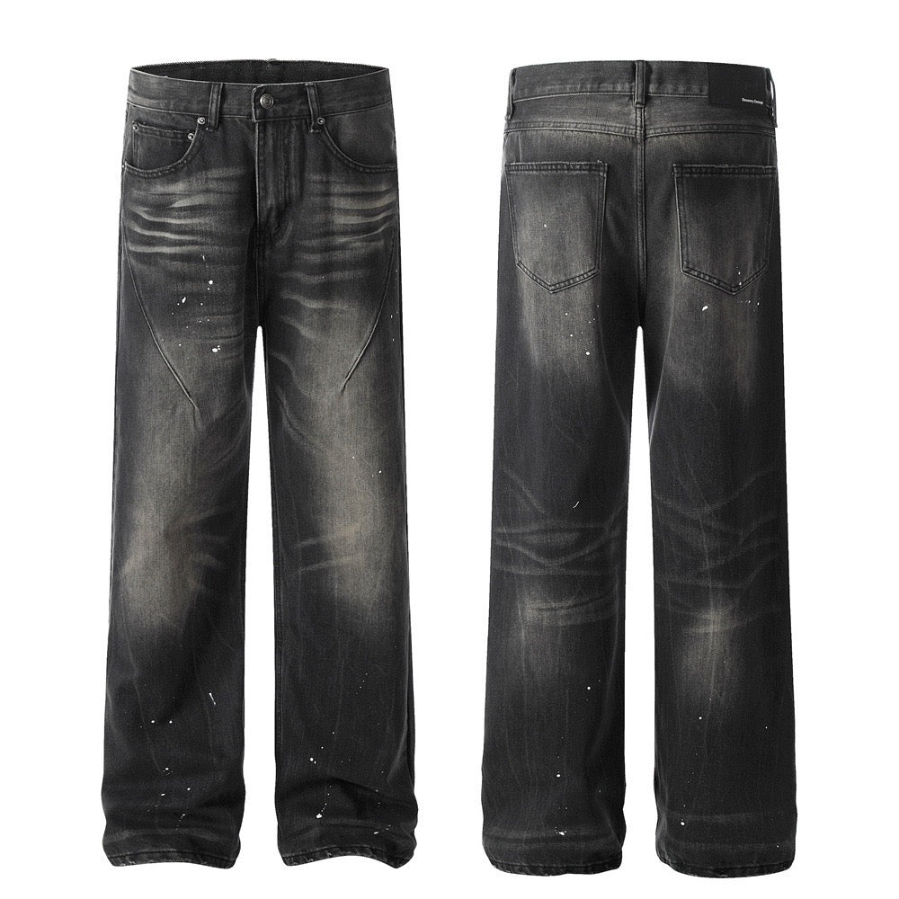 Front and back view of black wide-leg jeans with vintage fading, whisker details, and white paint-splatter accents